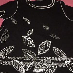 A black shirt with flower pedal design.